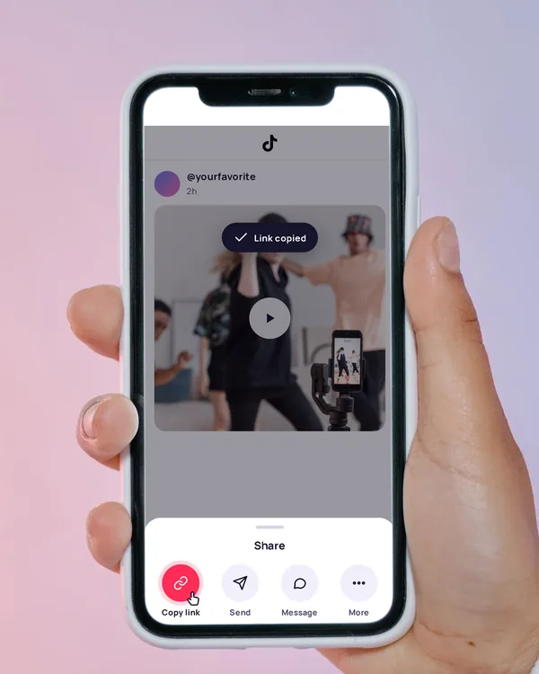 A hand holding a phone with the share menu open and Copy link selected